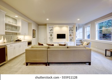 Chic Basement Features A Gray Sectional Facing A White Built-in Tv Cabinet And Wet Bar Mounted To A Wall. Northwest, USA
