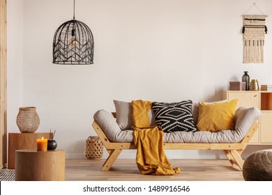 Chic, schwarzer Kronleuchter über Sofa im modernen Wohnzimmer