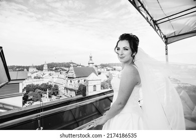 Chic Bride On The Balcony. Panorama Of The City. Bride Admiring The View