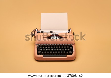 Chic retro typewriter with a paper sheet on the yellow background in the studio. Horizontal.