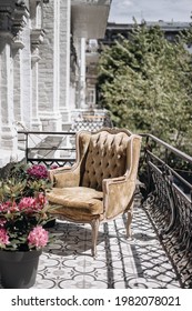 Chic Vintage Velvet Armchair On The Balcony. Sunny Day. Place For Relax. Flowers In Pots