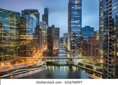 Chicago downtown skyline taken at Wolf Point in a fantastic cloudy evening, with lights of the skyscrapers reflected in the Chicago river, Illinois, United States