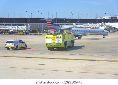 CHICAGO, IL -21 APR 2019- View Of A Yellow Firetruck Near An American Airlines (AA) Airplane At Chicago O'Hare International Airport (ORD).