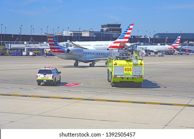 CHICAGO, IL -21 APR 2019- View Of A Yellow Firetruck Near An American Airlines (AA) Airplane At Chicago O'Hare International Airport (ORD).