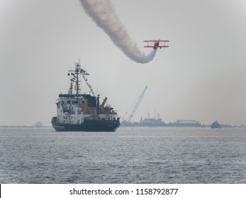 Chicago, IL - August 17th, 2018:  Sean D. Tucker and Team Oracle amuse the audience passing over a U.S. Coast Guard boat during a practice session over Lake Michigan for the annual Air and Water show.