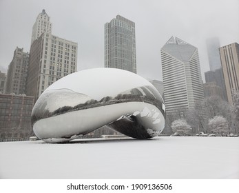 Chicago, IL January 26, 2021, The Bean, Cloud Gate In Millennium Park With Skyscrapers In The Background Covered In Snow During A Winter Snowstorm