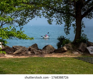 Chicago, IL - June 28th, 2020: Two People Set Out On A Calm Lake Michigan In Their White Colored Kayak Boat On A Warm Beautiful Summer Day.