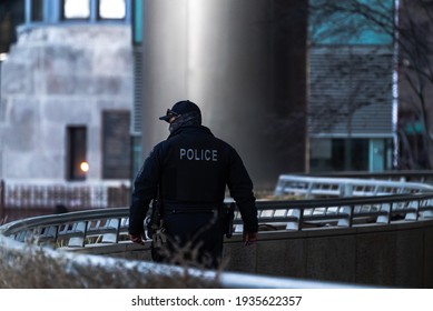 Chicago, IL - March 13th, 2021: A Member Of The Chicago Police Department Walks Along The Chicago River During The Surprise St. Patrick's Green Dye Event.