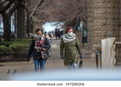 Chicago, IL March 14, 2021, Two Women Walking Down The Sidewalk Wearing Masks Due To The Covid 19 Pandemic