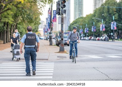Chicago, IL - September 16, 2021: A police officer walks along a street downtown in the Loop.