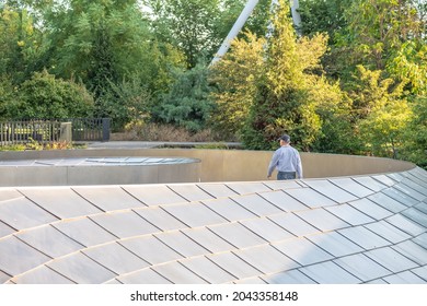 Chicago, IL - September 16, 2021: A man walks along the BP Bridge that connects Millennium Park and Maggie Daley Park, downtown in the Loop.
