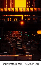 Chicago, IL - September 23rd, 2021: Light Shines Through Between Train Cars During The Fall Henge Where The Sun Aligns With The City's Street Grid Creating Long Shadows And Orange Light In The Street.