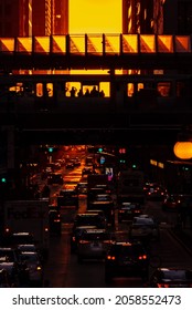 Chicago, IL - September 23rd, 2021: A CTA Train Passes Through The Washington And Wabash Stop Carrying Passengers As The Sun Sets Between The Buildings During The Semi Annual Henge Phenomenon.