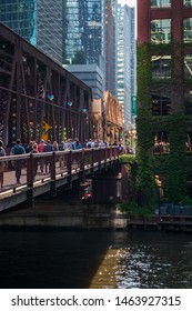 Chicago, IL / USA - 7/22/19: Commuters Walk Along The Lake Street Bridge Alongside The El Tracks And Over The Chicago River During Summer Morning