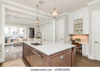 CHICAGO, IL, USA - APRIL 20, 2020: A Beautiful, Modern Kitchen With White Cabinets, Wood Island, And White Granite Counter Tops. High End, Stainless Steel Wolf And Subzero Appliances Finish The Space.