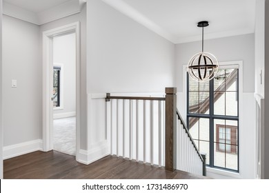 CHICAGO, IL, USA - APRIL 23, 2020: Looking Towards A White Bedroom And Stairwell With A Modern, Round Light Fixture Hanging From The High Ceiling.