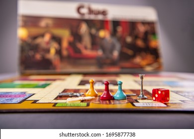 Chicago, IL / USA - April 5, 2020: Close Up Of The Pieces Of A Vintage Clue Game, Sitting On The Board, With The Box Behind. Illustrative Editorial.