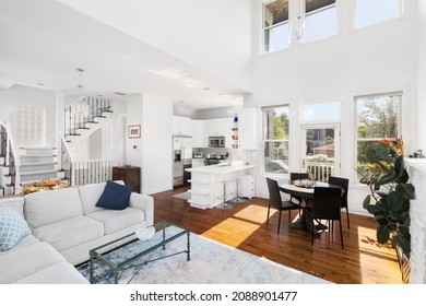 CHICAGO, IL, USA - AUGUST 2, 2021: A Luxury Home With Tall Ceilings Looking Towards A Dining Room, All White Kitchen, Living Room, And Staircase.