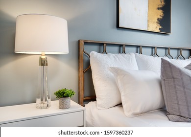 CHICAGO, IL, USA - DECEMBER 2, 2019: Detail Shot In A Blue Bedroom Of A Nightstand With A Lamp And Small Plant Next A Organized Bed.
