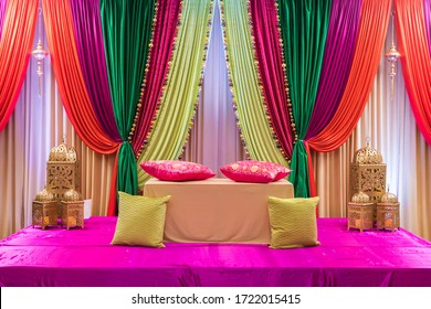 Chicago, IL USA February 1, 2019: Colorful wedding sangeet mehndi stage with pillows, lanterns, and beautiful red, purple, green and orange curtain draping