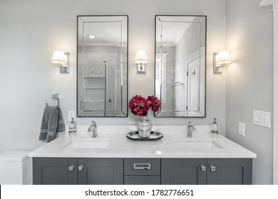 CHICAGO, IL, USA - FEBRUARY 7, 2020: A Luxurious Bathroom With A Grey Double Vanity With Flowers Sitting On The White Quartz Counter Top.