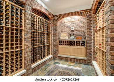 CHICAGO, IL, USA - FEBRUARY 8, 2019: A Large Walk-in Wine Cellar In A Luxury Home With Brick Walls And Wooden Wine Racks.