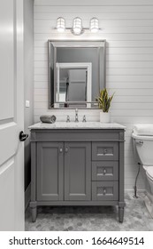 CHICAGO, IL, USA - JANUARY 27, 2020: A Remodeled Half Bath With A Grey Vanity And Marble Top With A Chrome Faucet. Shiplap Is On The Back Wall With Beautiful Octagon Tiles On The Floor.