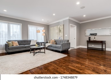 CHICAGO, IL, USA - JANUARY 27, 2020: A Spacious Living Room With Two Couches And A Fancy Lamp Overhead.