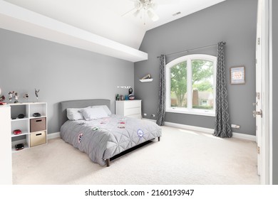 CHICAGO, IL, USA - JULY 20, 2021: A Large Bedroom With Grey And White Walls, Sports Memorabilia, And A Large Window.