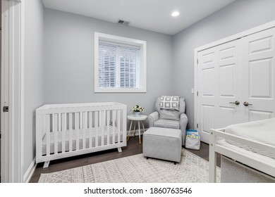 CHICAGO, IL, USA - JULY 5, 2020: A Nursery With A Rocking Armchair, A White Crib, And A Changing Table.