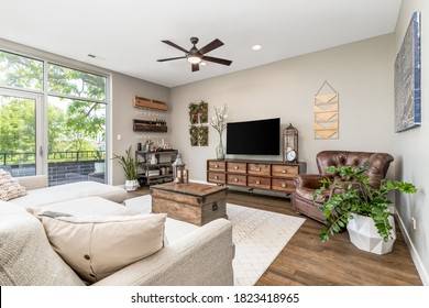 CHICAGO, IL, USA - JUNE 11, 2020: A Cozy Living Room Looking Over The Couch With Plants, A Television, And Bar Cart In This Chicago Condo.