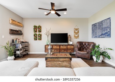 CHICAGO, IL, USA - JUNE 11, 2020: A Cozy Living Room Looking Over The Couch With Plants, A Television, And Bar Cart In This Chicago Condo.