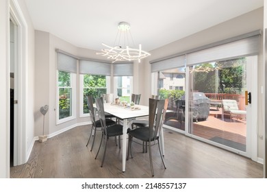 CHICAGO, IL, USA - JUNE 14, 2021: A Dining Room With Metal Chairs, A Modern Light Fixture, Hardwood Floors, And A View To An Outside Patio.