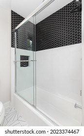 CHICAGO, IL, USA - JUNE 2, 2021: A Shower With Small Black Hexagon And Large White Hexagon Tiles In A Shower. The Floor Is Also A Patterned Black And White Tile.
