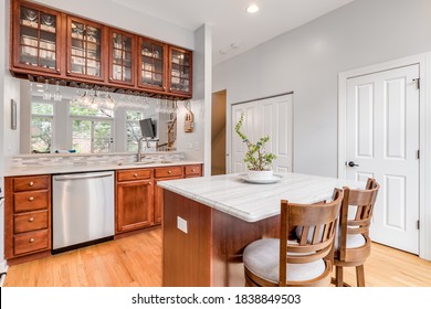 CHICAGO, IL, USA - JUNE 22, 2020: A Kitchen With Maple Wood Cabinets, A White Granite Counter Top, And Stainless Steel GE Appliances.