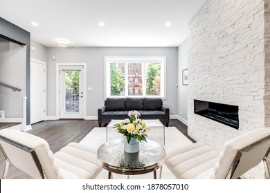 CHICAGO, IL, USA - JUNE 25, 2020: A Luxurious Living Room With A Couch And Chairs, A Rug On Dark Bamboo Hardwood Flooring, And A Modern Stone Fireplace.