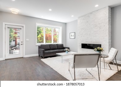 CHICAGO, IL, USA - JUNE 25, 2020: A Luxurious Living Room With A Couch And Chairs, A Rug On Dark Bamboo Hardwood Flooring, And A Modern Stone Fireplace.