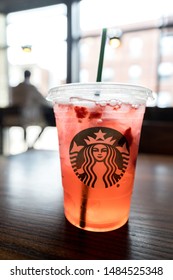 CHICAGO, IL, USA - JUNE 4, 2019: A Starbucks Cup Filled With A Strawberry Acai Refresher In The Restaurant With People Sitting In The Background.