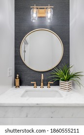 CHICAGO, IL, USA - JUNE 7, 2020: A Small Bathroom With Grey Wallpaper, Gold Hardware, And A White Marble Counter Top.