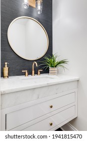 CHICAGO, IL, USA - JUNE 8, 2020: A Small Bathroom With Grey Wallpaper, Gold Hardware, And A White Marble Counter Top.