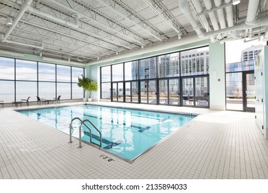CHICAGO, IL, USA - OCTOBER 1, 2021: An indoor pool in a downtown Chicago high rise with seating and a door that leads to an outdoor patio for the buildings residents.