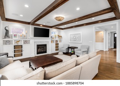 CHICAGO, IL, USA - OCTOBER 12, 2020: A Luxury, Modern Farmhouse Living Room With Wood Beams On The Ceiling, A Tiled Fireplace Surrounded By Built In Shelves And Furniture On The Hardwood Flooring.