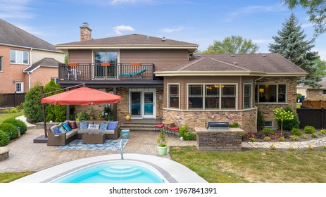 CHICAGO, IL, USA - SEPTEMBER 10, 2020: A Beautiful Backyard With An In Ground Pool, Seating Under An Umbrella, And A Concrete Patio.