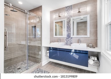 CHICAGO, IL, USA - SEPTEMBER 18, 2019: A Modern Bathroom With A Blue Cabinet, Tile And Stone Back Splash, And Marble Tiling The Floor / Shower.