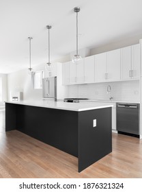 CHICAGO, IL, USA - SEPTEMBER 21, 2020: A Modern White Kitchen With A Black Island, Stainless Steel Appliances, White Granite Counter Tops, And A Chrome Faucet In Front Of A Subway Tile Back Splash.