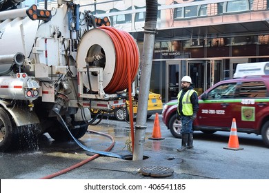 CHICAGO, ILLINOIS - APRIL 15, 2016: Hispanic worker monitors truck equipment inserting recoating of West Illinois Street sewer lines.