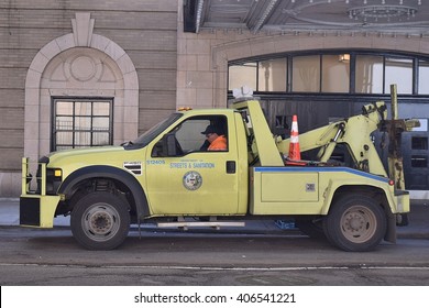 CHICAGO, ILLINOIS - APRIL 15, 2016: Chicago Streets and Sanitation tow truck patrols nearby the Chicago Theater entrance. 