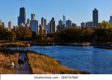 CHICAGO, ILLINOIS / UNITED STATES - OCTOBER 31, 2020: People Stroll Though Lincoln Park And Take In The Fall Foliage And The Chicago Skyline.