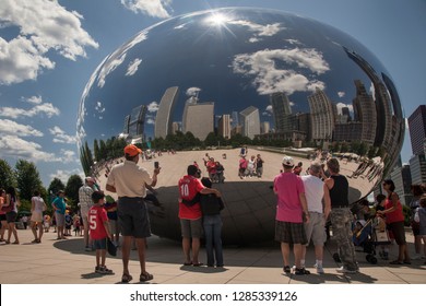 Chicago, Illinois, USA – August 02, 2009: Horizontal Shot Of People Self Portraying Their Reflections, With Chicago Skyline Background, At Anish Kapoor Cloud Gate (The Bean) Sculpture, Millenium Park