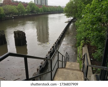 CHICAGO, ILLINOIS/MAY 19, 2020: Receding Chicago River Flood Water Leaves Muddy Residue On East Bank Club Walkways And Kayak Dock At West River Fulton